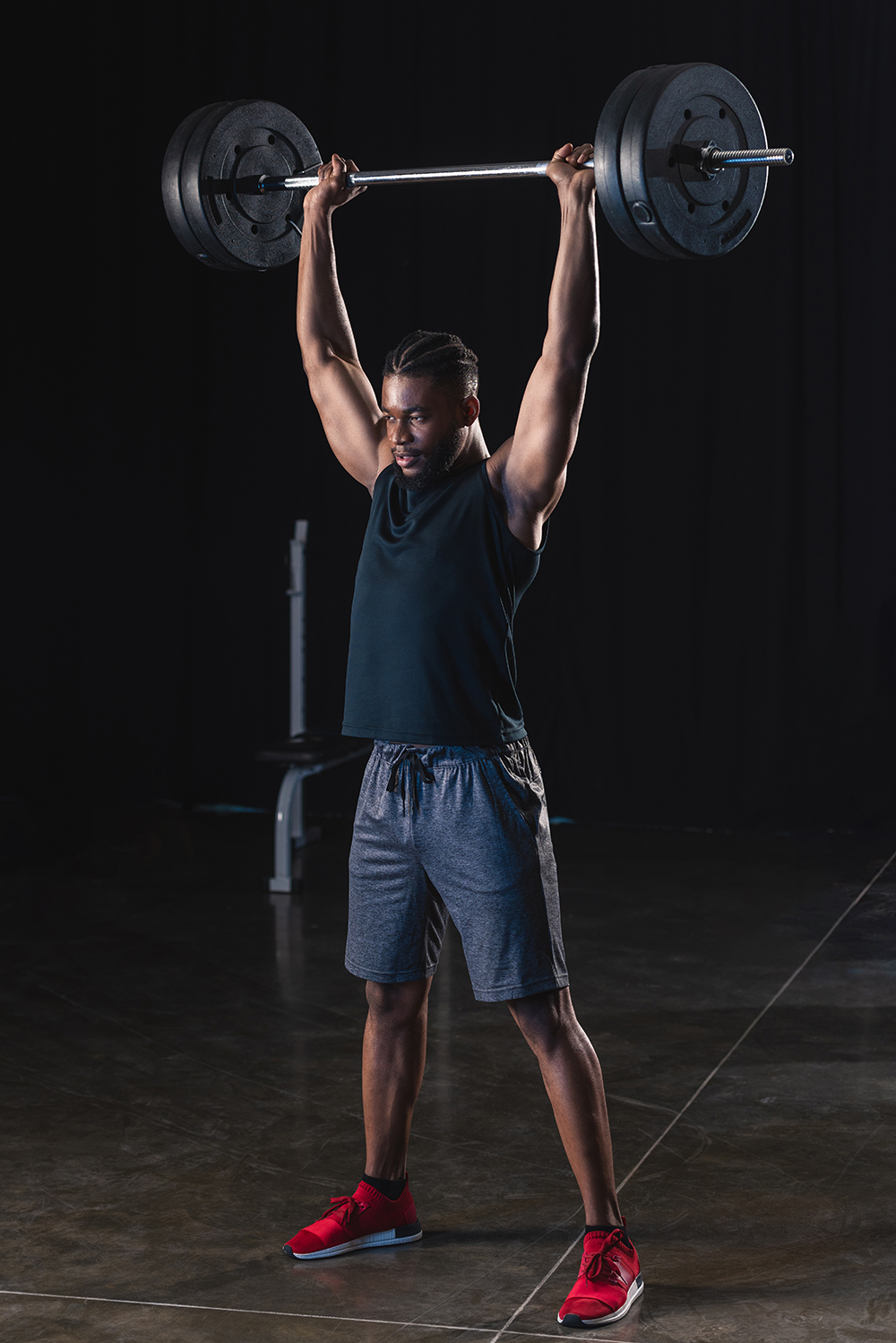 full length view of muscular african american sportsman lifting barbell in gym